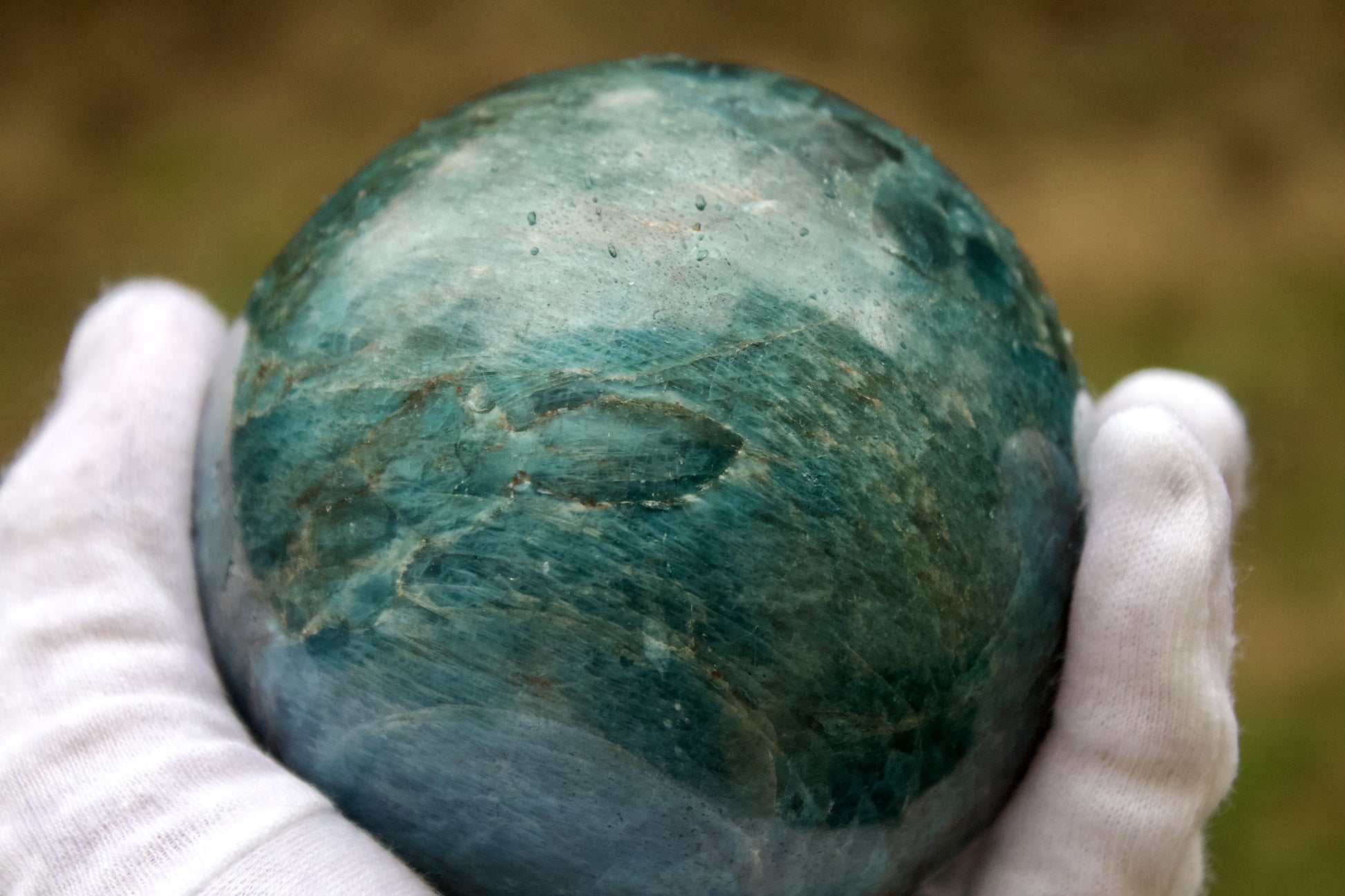 polished blue apatite sphere hand size reference